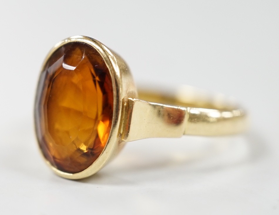 A George V 750 yellow metal and oval cut citrine set ring, size Q, gross weight 5.6 grams.